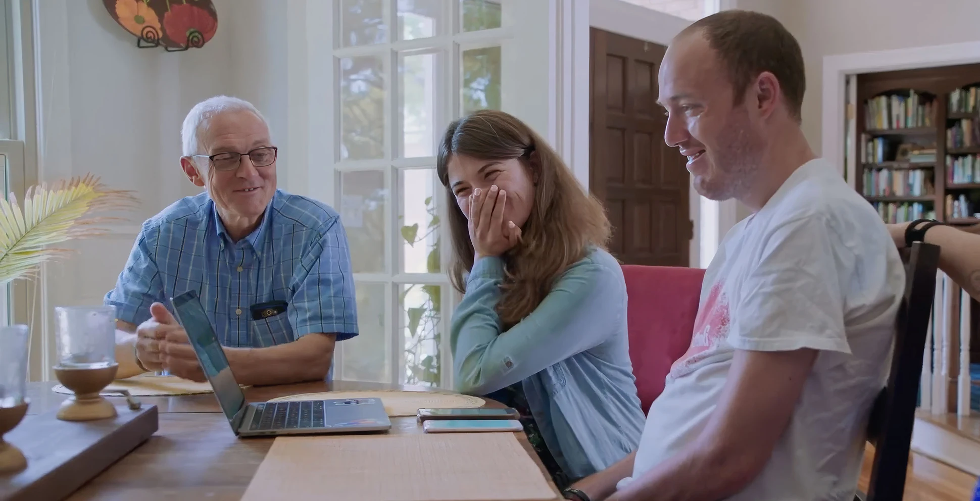 Video thumbnail of Tim Shaw sitting in front of a laptop next to his family, smiling.