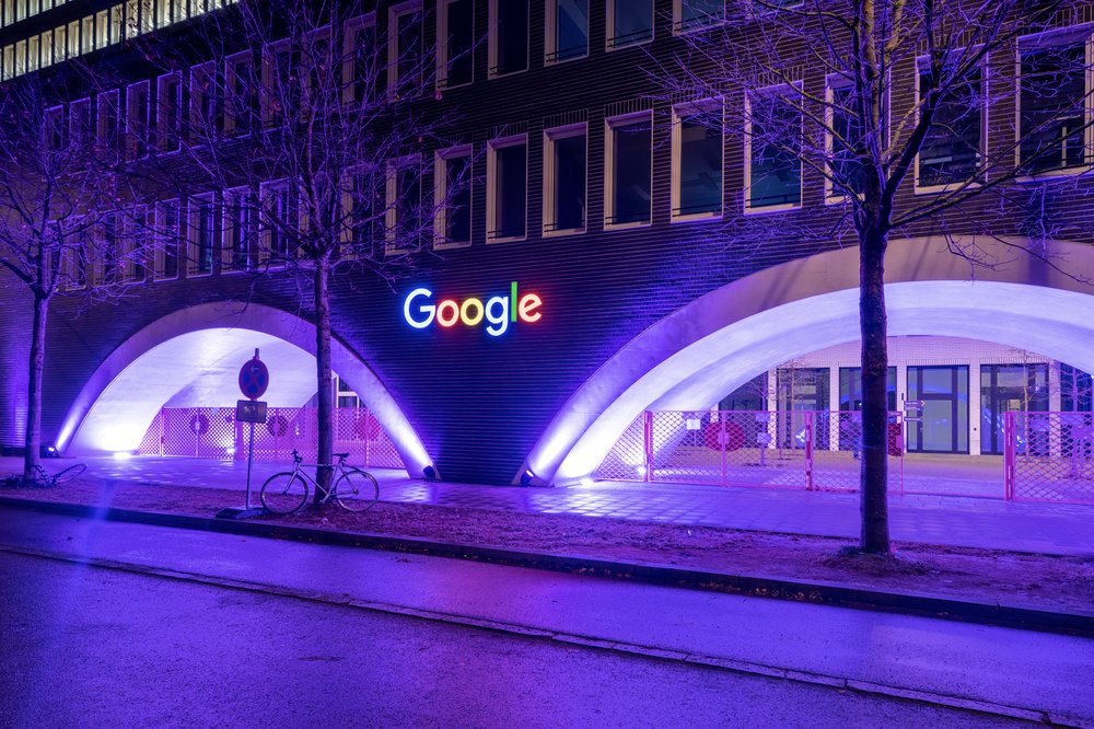 A Google office building at night. It's lit up purple to mark a special event.