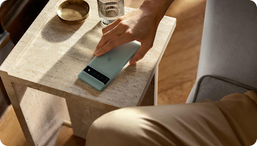Person placing Android phone on small table.