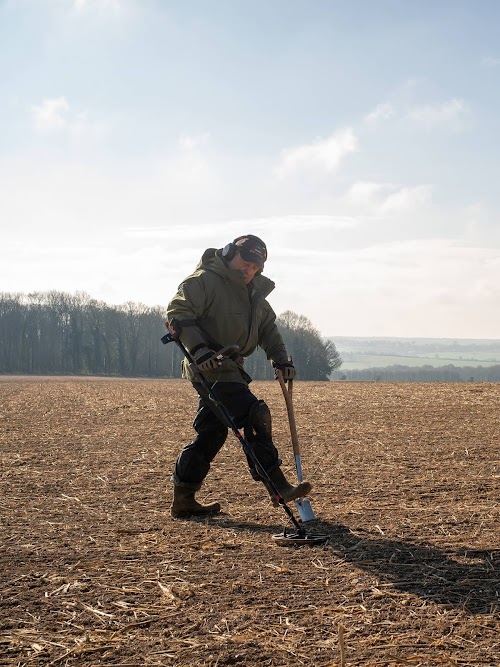 Peter Welch scanning a field with a metal detector
