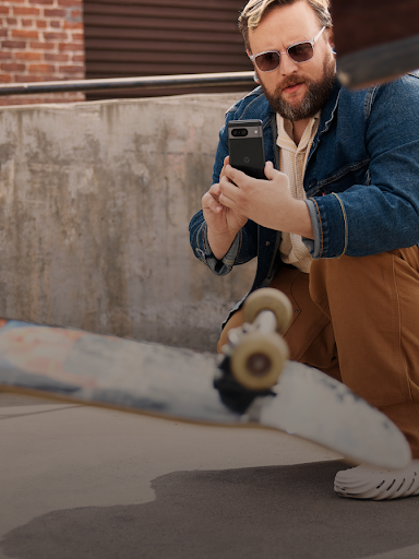 Android 使用者蹲著拍攝滑板手表演花式。