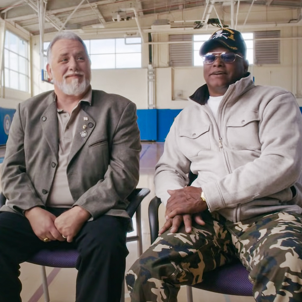 Dos veteranos sentados uno al lado del otro en un gimnasio durante un entrevista