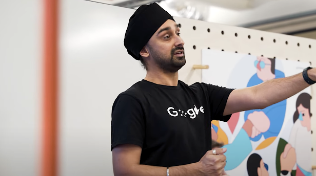 Un hombre barbado con turbante negro viste una camiseta con el logotipo de discapacidad de Google.