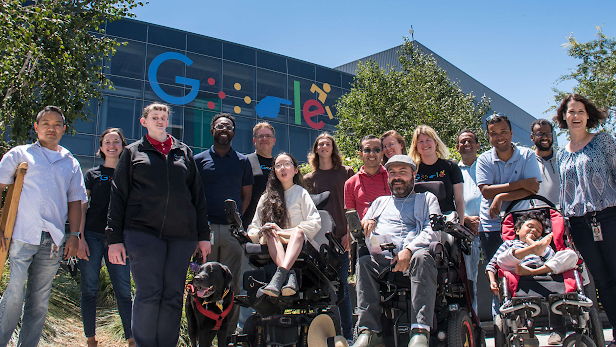 Miembros de la Alianza para la Discapacidad en Google frente a un edificio del campus con el logotipo de discapacidad de Google
