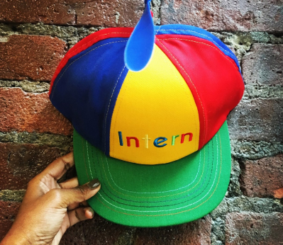 Intern hat against a brick wall