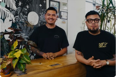 Two men in black tshirts at the front desk of their plant shop.