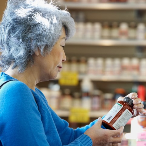 Woman looking at supplement bottle
